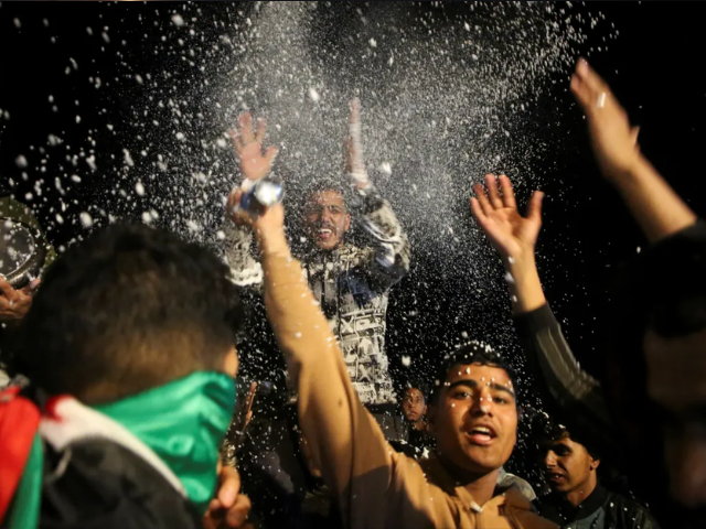 Palestinians react to news on a ceasefire deal with Israel, in Khan Younis in the southern Gaza Strip. [Hatem Khaled/Reuters]