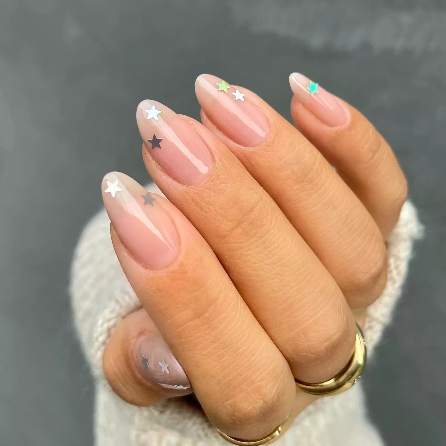 Sheer pink polish with two silver stars on each nail