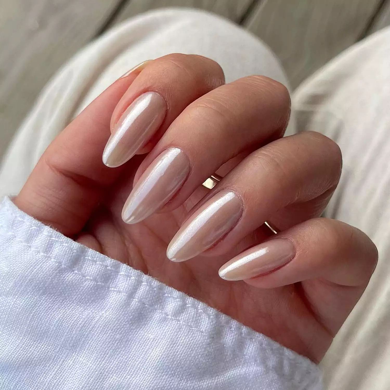 Folded hand with long pink chrome nails