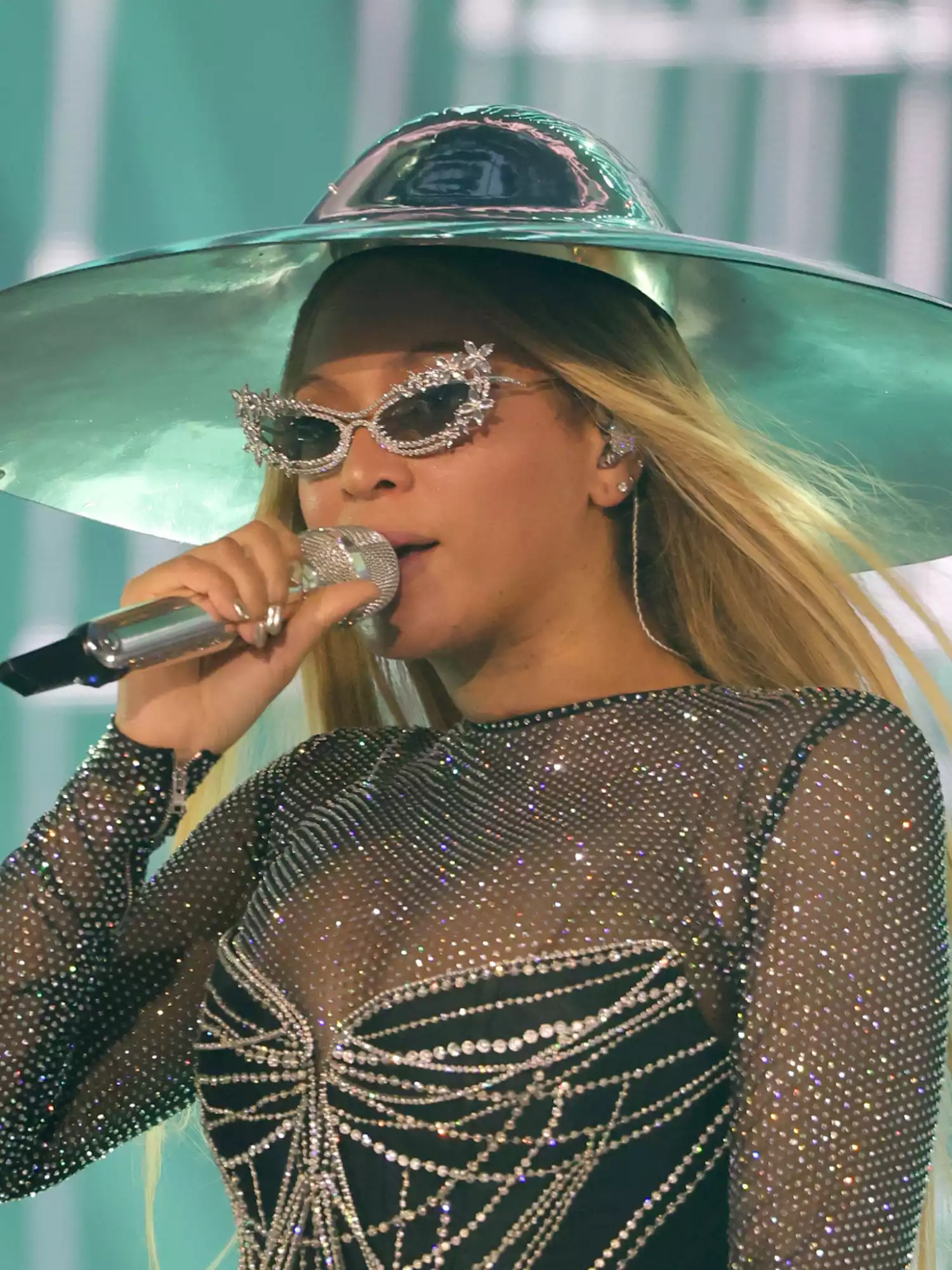 Beyonce singing on stage wearing silver rhinestone rimmed sunglasses